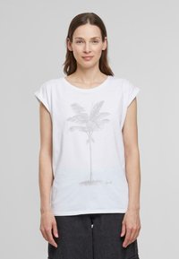 T-shirt en coton blanc avec des manches courtes retroussées. Présente un graphique de palmier gris clair imprimé sur le devant. Texture lisse, coupe décontractée.