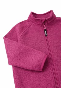 Kurtka z polaru w intensywnym różowym kolorze, z wysokim kołnierzem, pełnym zamkiem błyskawicznym i teksturowaną tkaniną. Zawiera kontrastowe mankiety oraz metkę marki.