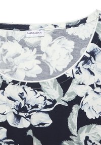 Top floreale blu navy con scollatura rotonda, caratterizzato da grandi fiori bianchi e foglie in tonalità di grigio. Tessuto di cotone morbido con dettagli cuciti.