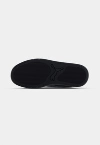 Zwarte sneakerzool met een gestructureerd grippatroon, voorzien van een centraal logo en gladde randen. Geen zichtbare merknaam of versieringen.