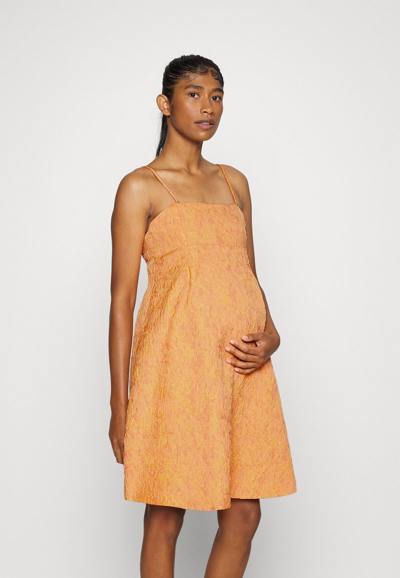 Vestido laranja texturizado com alças finas, corpete justo e saia fluida. O design apresenta um padrão sutil, que realça a sua aparência leve.