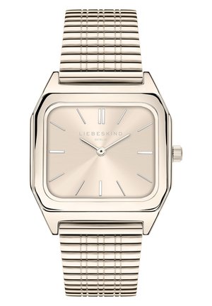 Montre carrée dorée avec un cadran beige brossé, des index horaires argentés et un bracelet en maille texturée. Présente une couronne sur le côté.