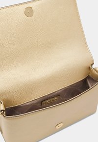 Sac en bandoulière en cuir texturé doré, doté d'une fermeture à pression, d'une doublure intérieure lisse et d'une étiquette de marque subtile à l'intérieur.
