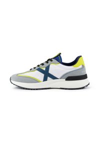 Baskets grises et blanches avec des accents bleus, présentant un design en daim et en maille, un bout rond, une semelle extérieure noire et des détails en jaune fluo.