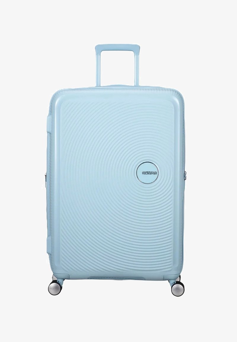 Valigia rigida di colore blu chiaro con un design a cerchi concentrici testurizzati. Dotata di manico telescopico e ruote girevoli fluide.