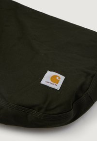 Tâmplă texturată, de culoare verde închis, cu o formă rotundă, având o etichetă albă ce prezintă un logo portocaliu și numele brandului.