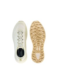 Scarpa sportiva chiara con tomaia testurizzata, lacci piatti e suola in gomma con motivi di trazione prominenti. Marchio dell'interno visibile.