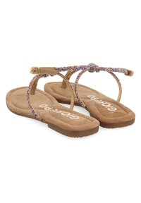 Sandalias de dedo de ante marrón con una tira de cuentas moradas y doradas, con diseño de tira y suela plana de goma. Logo de la marca visible en la plantilla.