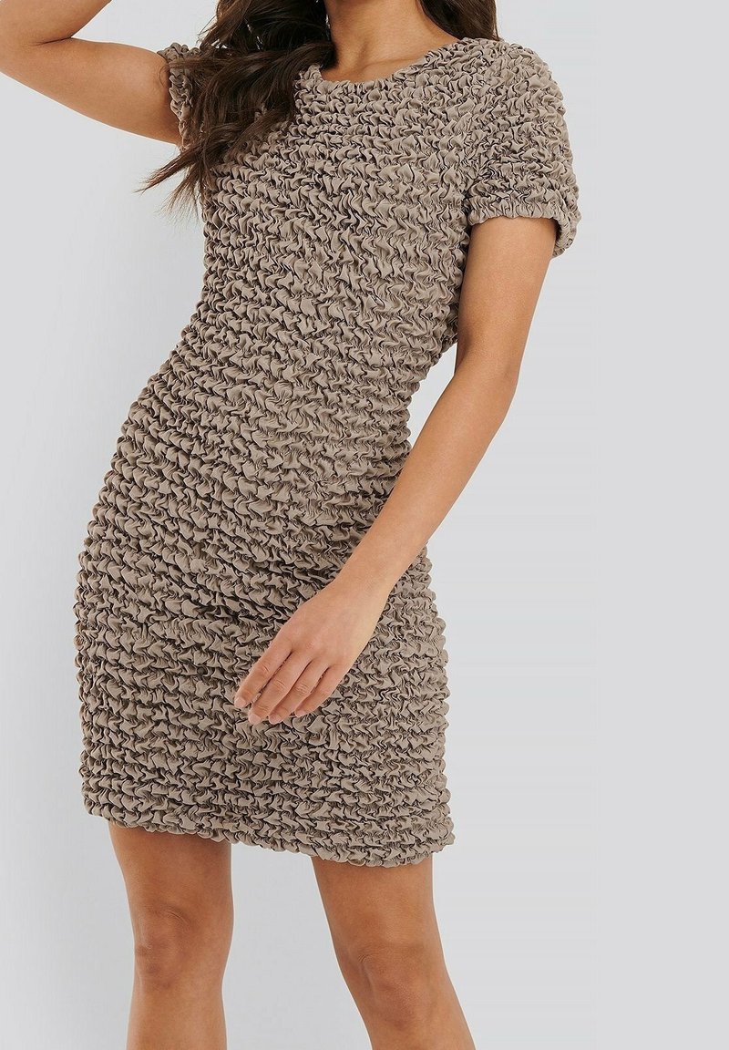 Beige jurk met korte mouwen van textuur, gegatherde stof. Strak silhouet met een ronde halslijn, knielange zoom en een zachte glans.
