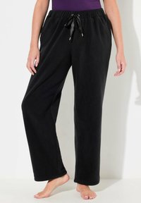 Zwarte fleece sweatpants met een trekkoord in de taille, zijzakken en een losse pasvorm. Gladde textuur, full-length ontwerp en subtiele stikseldetails.