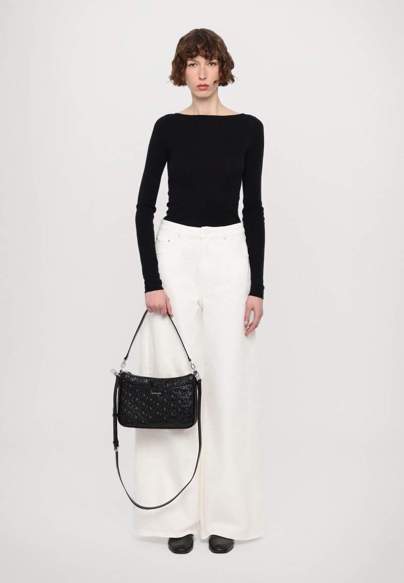 Top nero a maniche lunghe, pantaloni bianchi a gamba larga e una piccola borsa nera testurizzata con tracolla. Tessuto liscio e dettagli di design eleganti.