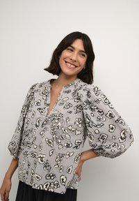 Blusa grigia con un motivo a stampa leopardata in nero e crema, con scollatura a V profonda, maniche arricciate e vestibilità rilassata.
