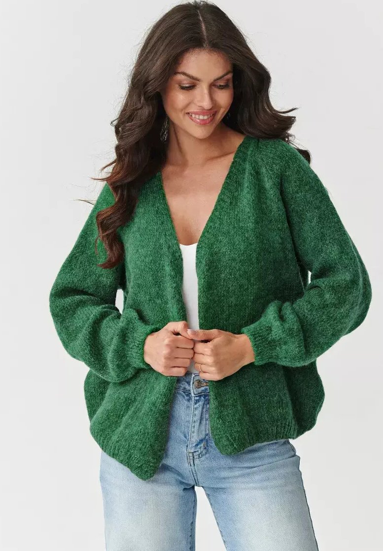 Zielony dzianinowy kardigan z dekoltem w szpic, długimi rękawami i luźnym krojem. Miękka faktura, otwarty przód, ściągacze na mankietach i u dołu. Noszony na białej bluzce.