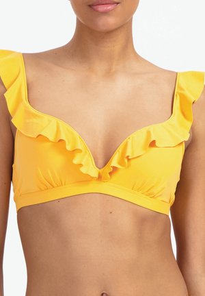 Frau trägt einen gelben Bikinioberteil mit gerafften Trägern und tiefem V-Ausschnitt, dargestellt von den Schultern bis zur Körpermitte vor weißem Hintergrund.