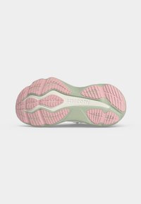 Σόλα παπουτσιού τρεξίματος Saucony με ροζ τμήματα πέλματος και ανοιχτοπράσινη βάση, που δείχνει το όνομα της μάρκας στη μεσαία σόλα.