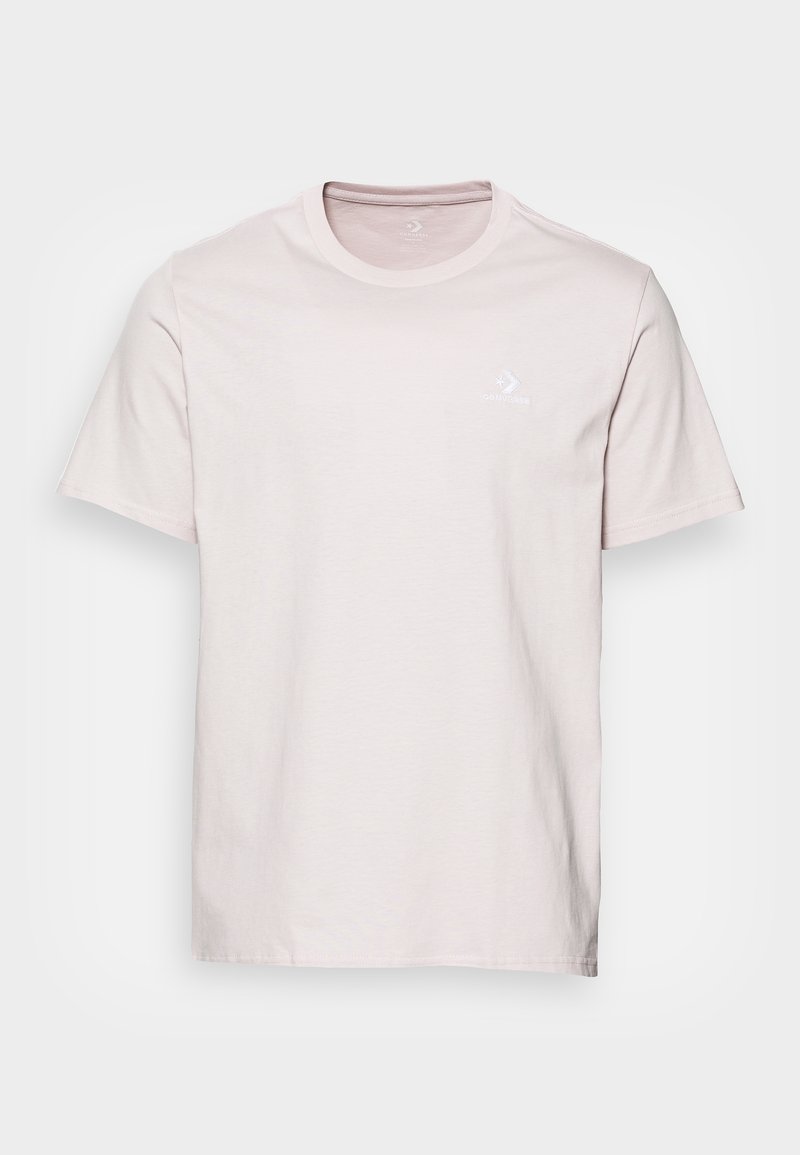 T-shirt en coton rose clair avec des manches courtes, un col rond et un petit logo blanc sur la poitrine gauche. Texture douce et coupe classique.