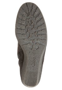 Bruine suède laars met een gestructureerde rubberen zool met een hexagonaal patroon en opvallende loopvlakken voor grip. Logo zichtbaar op de zool.