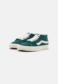 Grüne Wildleder-Hochtop-Sneaker mit weißen Lederakzenten, kontrastierenden Nähte und cremefarbenen Schnürsenkeln. Flache Gummisohle mit strukturiertem Grip.