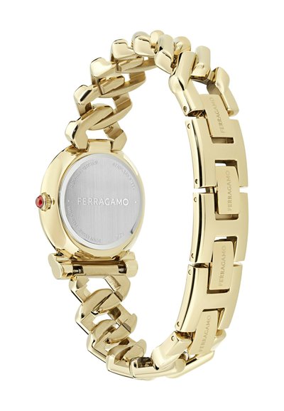 Gold-tone metal watch with a linked bracelet design. Round face features a stainless steel back and a red accent at the crown.