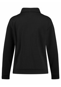 Sudadera negra con cuello, manga larga y corte relajado. Fabricada en un tejido suave, cuenta con puños acanalados y un dobladillo con aberturas laterales.