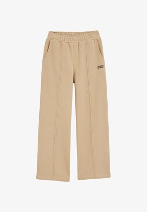Beige weite Sweatpants mit elastischem Bund, seitlichen Taschen und gesticktem schwarzen Text "LUCK ON MY SIDE" am linken Bein. Weicher Stoff.