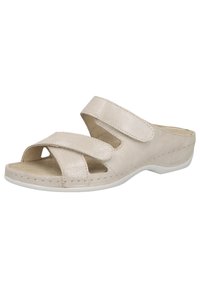 Beige slide sandal with cross-over straps, made of textured synthetic material. Features adjustable Velcro fasteners and a white outsole.