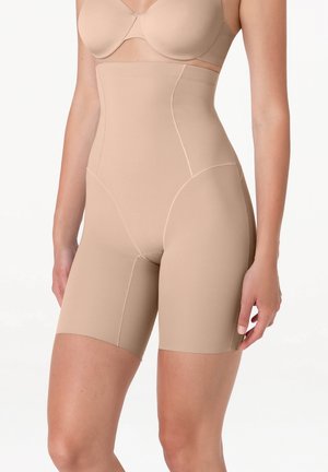 Shorts modellanti beige a vita alta indossati da una donna dalla metà del torace alla metà della coscia, abbinati a un reggiseno beige coordinato.