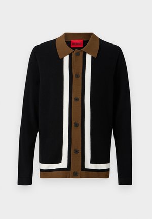 Black cardigan with a brown and white striped design, featuring a collar, button closure, and textured fabric.