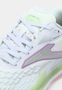 Scarpa sportiva bianca con texture in rete, lacci azzurri, dettagli viola, suola verde e marchio argentato sul lato e sulla linguetta.