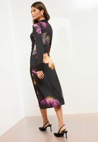 Rochie neagră cu imprimeu floral, cu mâneci lungi și croială de lungime medie, având flori roz și portocalii. Material texturat; detaliu cu slit pe lateral.