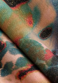 Tessuto testurizzato con un motivo astratto colorato caratterizzato da accenti di blu, rosa e nero, intrecciato con fili d'oro per un effetto luminoso.