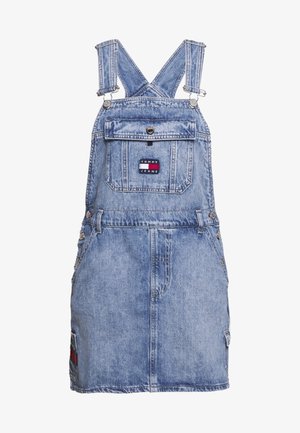 Spijkerjurk in lichtblauw. Verstelbare bandjes, voorzak en een logo-patch aan de achterkant met rode en blauwe accenten. Voorzien van metalen hardware.