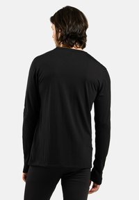 Black long-sleeve shirt in a smooth fabric. Features a crew neckline and fitted silhouette. Back view shows long sleeves and soft texture.