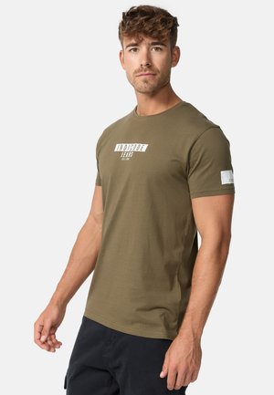 Camiseta de algodón verde olivo con un estampado de logo blanco en el pecho y una pequeña etiqueta blanca en la manga. Cuello redondo clásico.