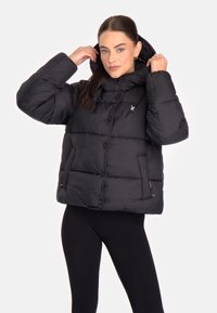 Giubbotto puffo nero con cappuccio, caratterizzato da un design trapuntato, chiusura con bottoni e tasche laterali. Realizzato in un materiale liscio e leggero.