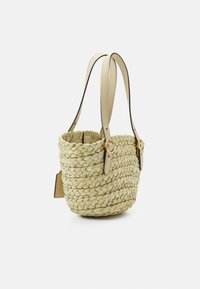 Torebka typu wiaderko z plecionej słomy w naturalnym beżu z dwoma kremowymi skórzanymi pasek oraz złotymi akcentami, z teksturowanym wykończeniem.