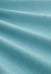 Tkanina turkusowa o gładkiej fakturze, z delikatnymi zagnieceniami i równomiernym rozkładem kolorów, idealna do zastosowań tekstylnych lub odzieżowych.