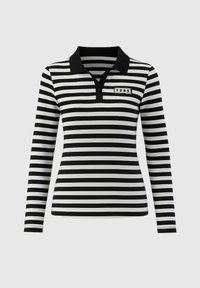 Polo shirt à rayures noires et blanches à manches longues avec un col noir et un petit patch rectangulaire affichant "1985" près des boutons.