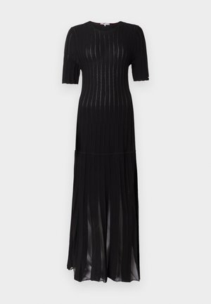 Schwarzes Strickkleid mit gerippter Textur, kurzen Ärmeln und einem bodenlangen Schnitt. Verfügt über einen subtilen Glanz und vertikale Streifen als Detail.