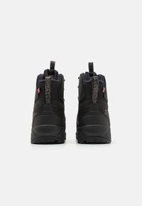 Schwarze High-Top-Schuhe aus strukturiertem Stoff, mit verstärkten Sohlen und reflektierenden Akzenten. Verfügt über einen gepolsterten Kragen und eine Zuglasche für einfaches Anziehen.