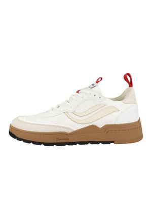 Zapatilla blanca de perfil bajo con detalles beige, tiradores rojos en el talón y la lengüeta, suela gruesa marrón y banda de rodadura negra, vista lateral que muestra un diseño ondulado.