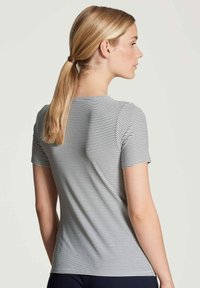 Korte mouwen shirt van een lichtgewicht, rekbaar materiaal. Heeft horizontale zwart-witte strepen, met een ronde halslijn en een getailleerde pasvorm.