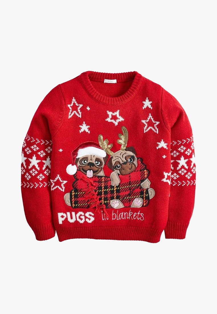 Pull de Noël rouge avec deux carlins brodés enveloppés dans une couverture à carreaux, l'un portant un chapeau de Père Noël, l'autre des bois de renne, entourés d'étoiles blanches.