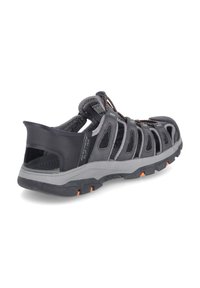 Men’s black walking sandal with mesh panels, rubber sole, grey accents, and orange detailing. Open-back design for breathability and comfort.