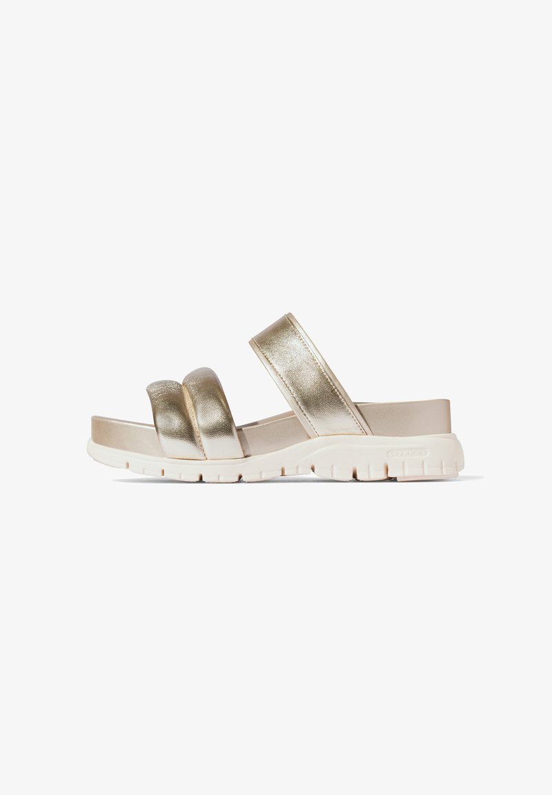 Metallic gold Riemensandalen mit zwei breiten Riemen, einem geformten Fußbett und einer leichten Gummisohle mit flachen Profil für besseren Halt.