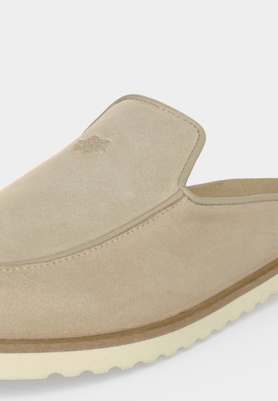 Μπεζ καστόρινο παπούτσι χωρίς κορδόνια με στρογγυλεμένη τετράγωνη μύτη, ραφές λεπτομέρειες και λευκή ραβδωτή ελαστική σόλα.