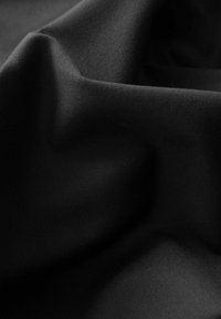 Black fabric with a smooth texture, showcasing draped folds and subtle sheen. The material appears soft and lightweight.