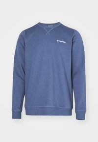 Niebieska bluza z miękkiego materiału, z okrągłym dekoltem, długimi rękawami, ribbowymi mankietami oraz małym białym logo Columbii na piersi.