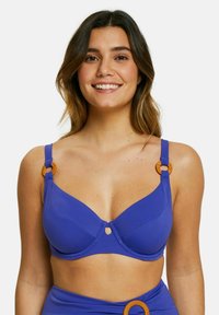 Soutien-gorge de bikini violet avec un tissu lisse, soutien-gorge à armatures, détail en trou de serrure au centre, et accents en métal circulaire orange sur les bretelles.