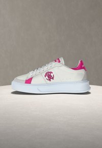 Λευκό χαμηλό αθλητικό παπούτσι με ροζ λεπτομέρειες, λογότυπο μονόγραμμα στη πλευρά, κορδόνια και χοντρή λευκή σόλα, σε ουδέτερο φόντο.